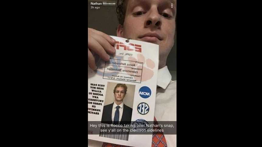 A Clemson University student holds up the ESPN ID badge he faked to get on the sidelines of a recent game.