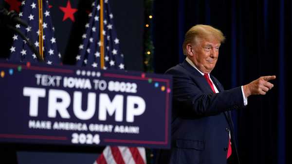 Former President Donald Trump greets supporters as he arrives at a commit to caucus rally, on Dec. 19, in Waterloo, Iowa.
