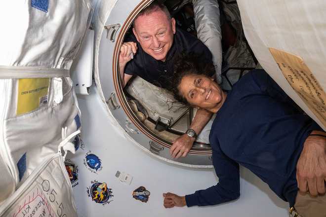In this photo provided by NASA, Boeing Crew Flight Test astronauts Butch Wilmore, left, and Suni Williams pose for a portrait inside the vestibule between the forward port on the International Space Station's Harmony module and Boeing's Starliner spacecraft on June 13, 2024.