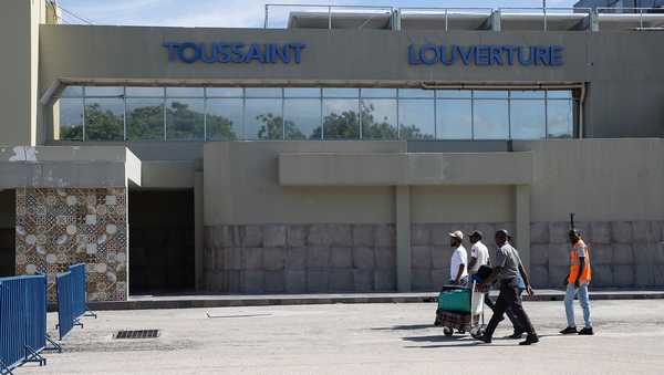 Travelers walk in front of the Toussaint Louverture International Airport in Port-au-Prince in May 2024.