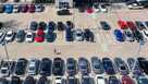 In an aerial view, a customer walks through a Carmax dealership.