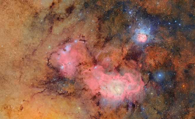 This composite image combines 678 separate images to show faint details like clouds of gas and dust in the Trifid nebula (top right) and the Lagoon nebula.