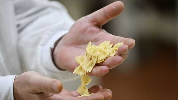 A staff member shows farfalle pasta on the production line of the Barilla factory. Barilla is one of 13 Italian pasta companies set to face higher tariffs on exports to the United States later this year.