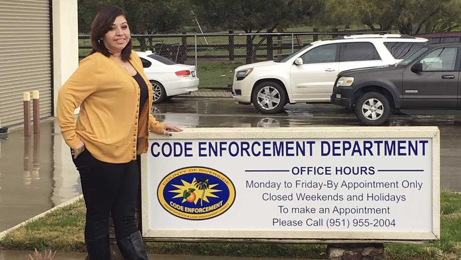 This undated photo provided by the County of Riverside Code Enforcement Department shows code enforcement employee Angie Solis standing outside the agency's office in Riverside, Calif. A woman, Amanda Tadeo, was in labor and being driven to a hospital by her husband Oswaldo on Wednesday, Jan. 16, 2019 when they realized they wouldn't make it in time. They stopped their van at the code enforcement office as Solis was arriving, and she helped deliver the baby in the parking lot.