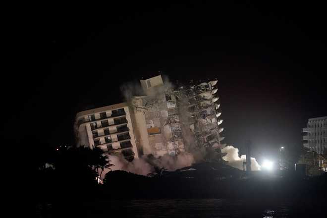 The damaged remaining structure at the Champlain Towers South condo building collapses in a controlled demolition, Sunday, July 4, 2021, in Surfside, Fla. The decision to demolish the Surfside building came after concerns mounted that the damaged structure was at risk of falling, endangering the crews below and preventing them from operating in some areas.