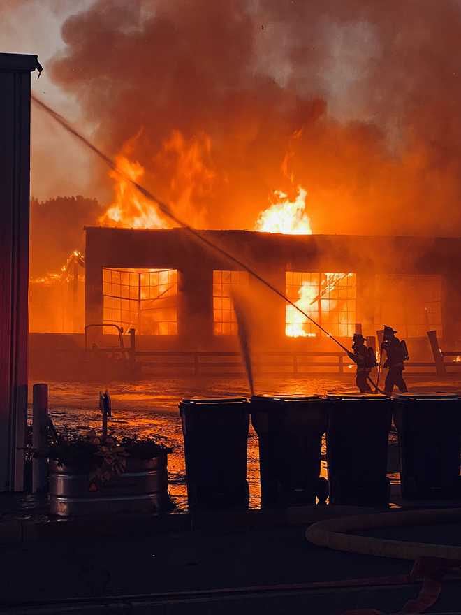 Los bomberos trabajan para apagar un incendio en un negocio de antigüedades en Columbia, condado de Lancaster.