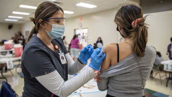 A young woman gets her second dose of the Moderna Covid-19 vaccine at a vaccination site at a senior center on March 29, 2021 in San Antonio, Texas.