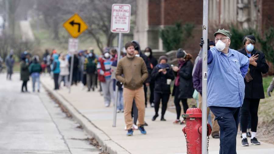 In this April 7, 2020 file photo, voters observe social distancing guidelines as they wait in line to cast ballots in the presidential primary election in Milwaukee.