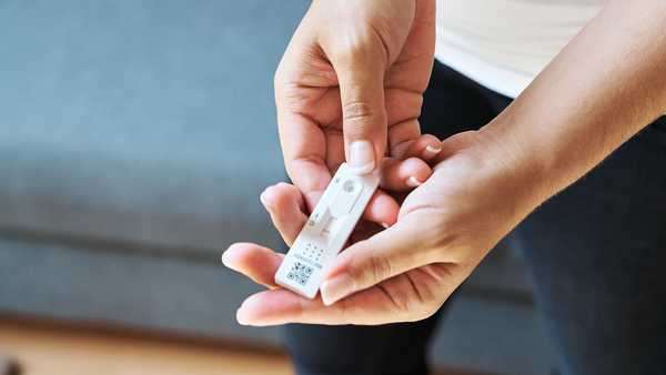 Stock photo of a person holding a COVID-19 rapid antigen test