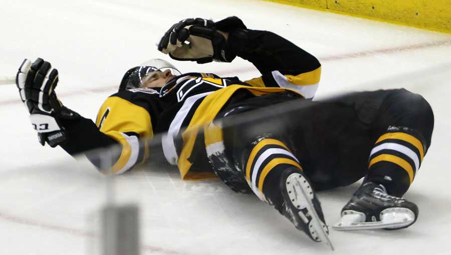 Sidney Crosby lies on the ice after taking a hit from Matt Niskanen.
