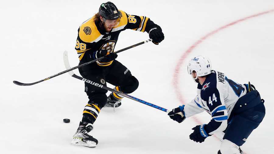 Winnipeg Jets' Josh Morrissey (44) battles Boston Bruins' David Pastrnak (88) for the puck during the third period of an NHL hockey game, Saturday, Jan. 22, 2022, in Boston. (AP Photo)
