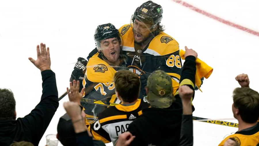 Boston Bruins' Connor Clifton, left, celebrates with David Pastrnak, right, after Pastrnak scored in the third period of Game 4 of an NHL hockey Stanley Cup first-round playoff series against the Carolina Hurricanes, Sunday, May 8, 2022, in Boston. The Bruins won 5-2.