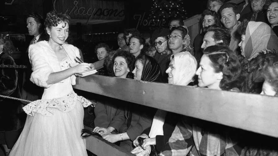 Debbie Reynolds signs autographs at a 1949 movie premiere for 'The Hasty Heart.'
