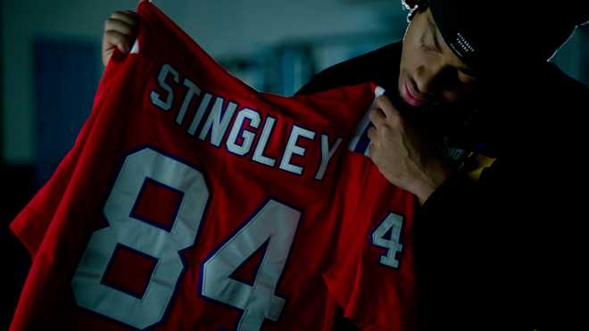 ﻿Derek Stingley Jr. holds up the No. 84 New England Patriots  x20;jersey of his late grandfather, Darryl Stingley.