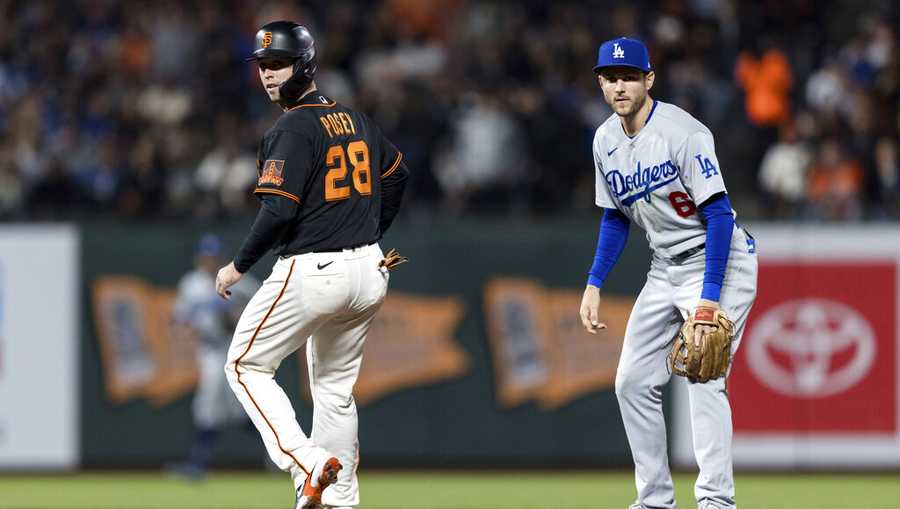 San Francisco Giants&apos; Buster Posey (28) and Los Angeles Dodgers second baseman Trea Turner (6) watch the play at first base in the sixth inning of a baseball game in San Francisco, Saturday, Sept. 4, 2021. (AP Photo/John Hefti)