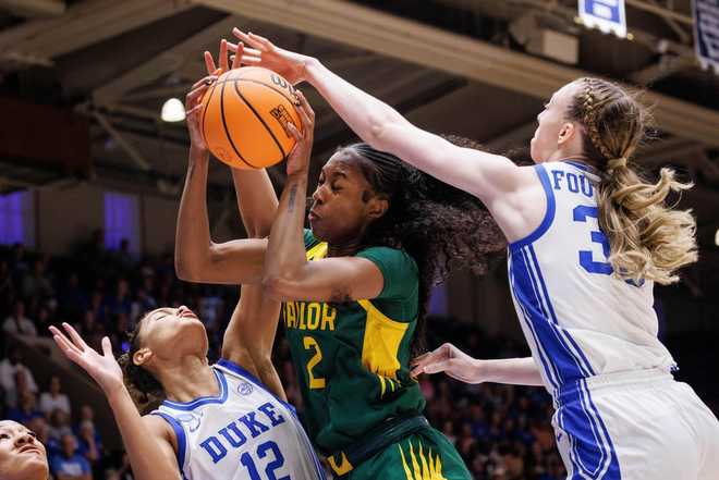 Baylor's Kiersten Johnson (2) grabs a rebound between Duke's Delaney Thomas (12) and Duke's Toby Fornier (35) during the first half in the second round of the NCAA college basketball tournament, Sunday, March 22, 2026 in Durham, N.C.