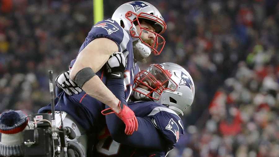 New England Patriots wide receiver Julian Edelman, top, gets a lift from offensive tackle Isaiah Wynn after catching a pass for a two-point conversion in the second half of an NFL football game against the Buffalo Bills, Saturday, Dec. 21, 2019, in Foxborough, Mass.