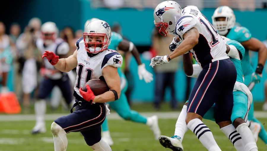 New England Patriots wide receiver Julian Edelman (11) runs for a touchdown as wide receiver Michael Floyd (14) bumps Miami Dolphins cornerback Tony Lippett (36) out of the way, during the second half of an NFL football game, Sunday, Jan. 1, 2017, in Miami Gardens, Fla. 