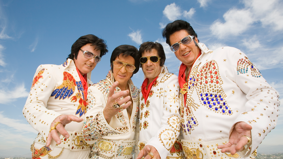 Four men dressed as Elvis Presley posing, gesturing, portrait