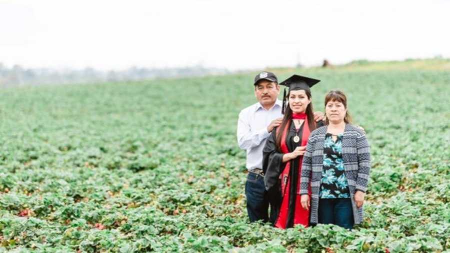 Erica Alfaro posed with her parents in the strawberry fields where they work 10-hour days, 7 days a week to honor their sacrifices. She graduated this year with her master's degree from San Diego State University.