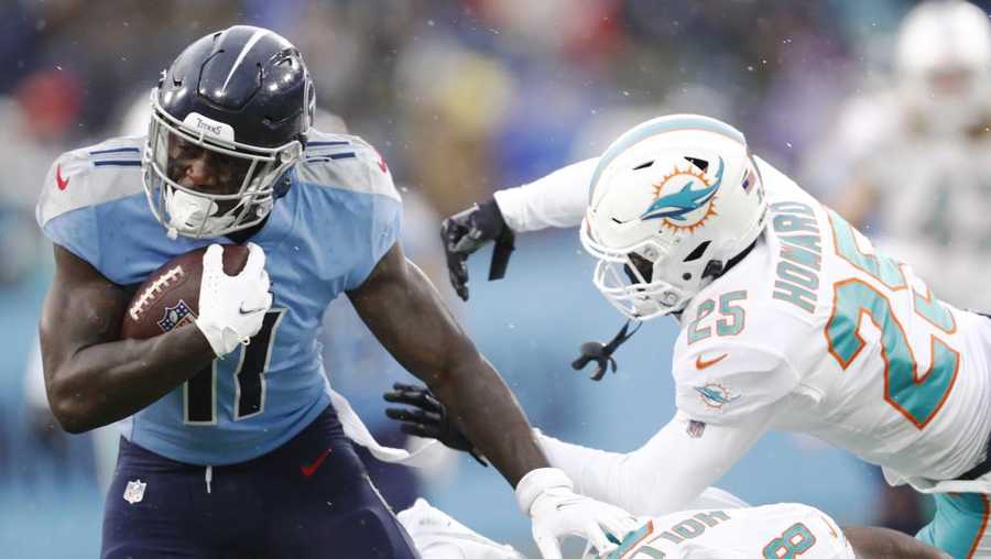 tennessee titans wide receiver a.j. brown (11) gets past miami dolphins defenders miami dolphins xavien howard (25) and jevon holland (8) in the first half of an nfl football game sunday, jan. 2, 2022, in nashville, tenn. (ap photo/wade payne)