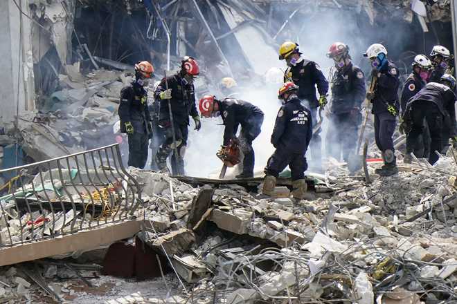 Crews work in the rubble at the Champlain Towers South Condo, Sunday, June 27, 2021, in Surfside, Fla. Many people were still unaccounted for after Thursday's fatal collapse. (AP Photo/Wilfredo Lee)