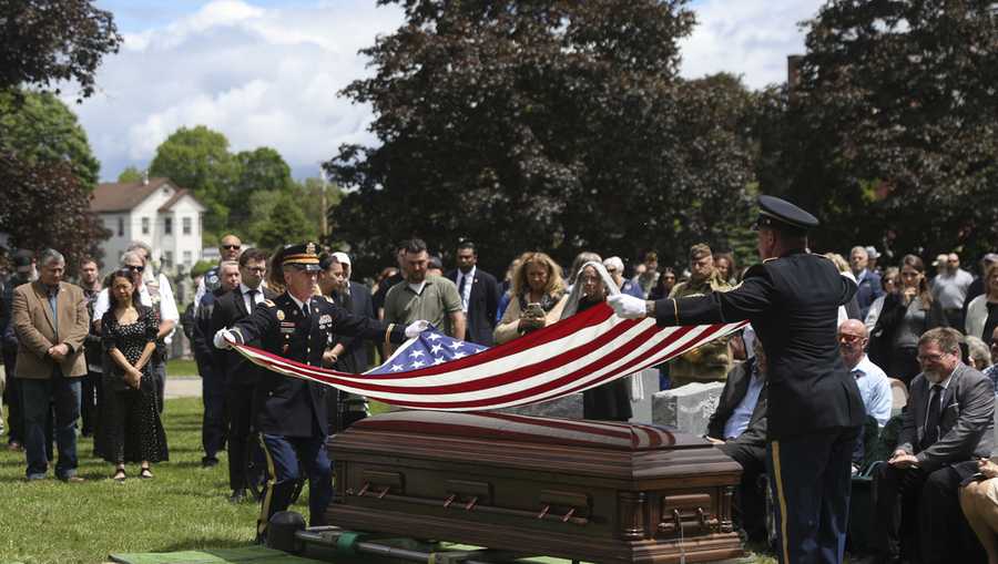 An American flag is folded during the interment for World War II U.S. Army Air Forces Staff Sgt. Eugene Darrigan at the cemetery behind St. Mary&apos;s church.