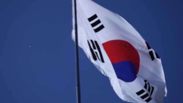 A South Korean national flag flutters in the wind at the Unification Observation Post as North Korean balloons, left, fly in Paju, South Korea, near the border with North Korea, Friday, Oct. 4, 2024.