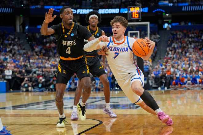 Florida guard Urban Klavzar (7) drives past Prairie View A&amp;M forward Corey Dunning (4) during the first half in the first round of the NCAA college basketball tournament, Friday, March 20, 2026, in Tampa, Fla.