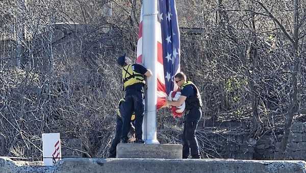 crews work to raise a new american flag