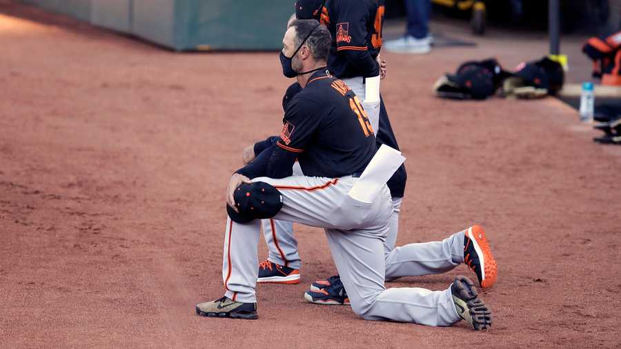 San Francisco Giants manager Gabe Kapler kneels during the national anthem prior to an exhibition baseball game against the Oakland Athletics on July 20.