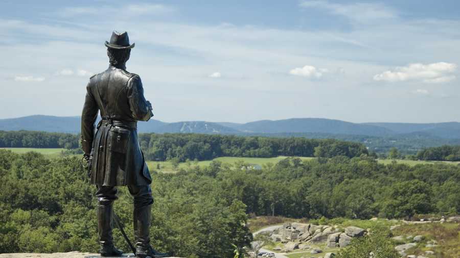 General Warren statue standing on Little Round Top overlooking Devil&apos;s Den below, American Civil War, Gettysburg National Military Park, PA, USA.