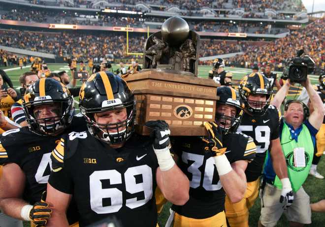 IOWA&#x20;CITY,&#x20;IOWA-&#x20;SEPTEMBER&#x20;08&#x3A;&#x20;&#x20;Offensive&#x20;lineman&#x20;Keegan&#x20;Render&#x20;&#x23;69&#x20;and&#x20;defensive&#x20;back&#x20;Jake&#x20;Gervase&#x20;&#x23;30&#x20;of&#x20;the&#x20;Iowa&#x20;Hawkeyes&#x20;carry&#x20;the&#x20;Cy-Hawk&#x20;trophy&#x20;after&#x20;the&#x20;match-up&#x20;against&#x20;the&#x20;Iowa&#x20;State&#x20;Cyclones&#x20;on&#x20;September&#x20;8,&#x20;2018&#x20;at&#x20;Kinnick&#x20;Stadium,&#x20;in&#x20;Iowa&#x20;City,&#x20;Iowa.&#x20;&#x20;&#x28;Photo&#x20;by&#x20;Matthew&#x20;Holst&#x2F;Getty&#x20;Images&#x29;