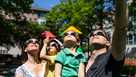 A family looks at the solar eclipse in a public park
