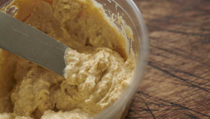 A close-up shot of hummus with a knife is shown in this file photo.