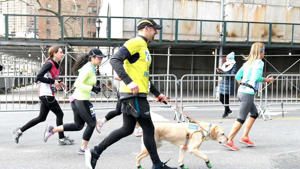 'It's really a team' Blind runner, guide dog trio make history running