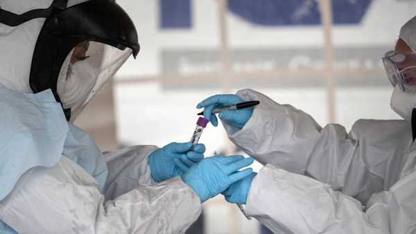 STAMFORD, CT - MARCH 23: Health workers dressed in personal protective equipment (PPE) handle a coronavirus test at a drive-thru testing station at Cummings Park on March 23, 2020 in Stamford, Connecticut. Availability of protective clothing for medical workers has become a major issue as COVID-19 cases surge throughout the United States. The Stamford site is run by Murphy Medical Associates. (Photo by John Moore/Getty Images)