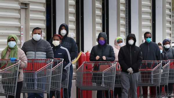 Customers wear face masks to prevent the spread of the novel coronavirus as they line up to enter a Costco Wholesale store April 16, 2020 in Wheaton, Maryland. Maryland Governor Larry Hogan ordered that all people must wear some kind of face mask to protect themselves and others from COVID-19 when on public transportation, grocery stores, retail establishments and other places where social distancing is not always possible.