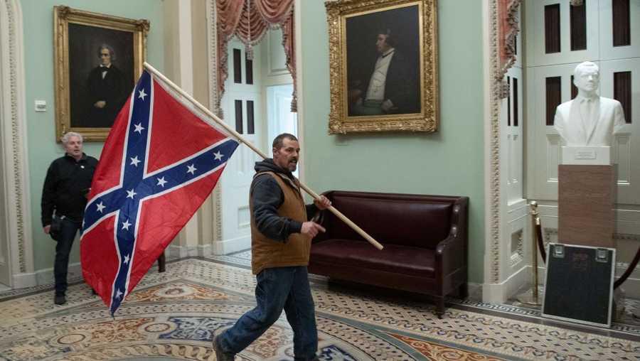 A protester carries a  Confederate flag during riots at the U.S. Capitol Jan. 6, 2021, in Washington, D.C. (Photo by SAUL LOEB / AFP) (Photo by SAUL LOEB/AFP via Getty Images)