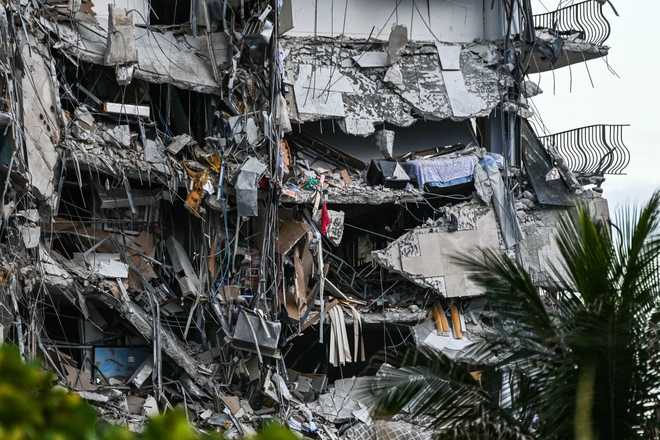 Rubble hangs from a partially collapsed building in Surfside north of Miami Beach, on June 24, 2021. -