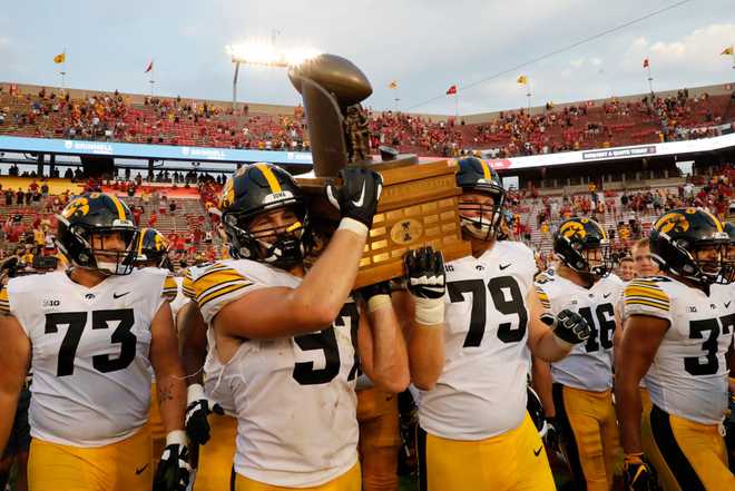 AMES,&#x20;IA&#x20;-&#x20;SEPTEMBER&#x20;11&#x3A;&#x20;Defensive&#x20;lineman&#x20;Zach&#x20;VanValkenburg&#x20;&#x23;97&#x20;of&#x20;the&#x20;Iowa&#x20;Hawkeyes&#x20;and&#x20;offensive&#x20;lineman&#x20;Jack&#x20;Plumb&#x20;&#x23;79&#x20;of&#x20;the&#x20;Iowa&#x20;Hawkeyes&#x20;carry&#x20;the&#x20;Cy-Hawk&#x20;Trophy&#x20;off&#x20;the&#x20;field&#x20;after&#x20;defeating&#x20;the&#x20;Iowa&#x20;State&#x20;Cyclones&#x20;27-17&#x20;at&#x20;Jack&#x20;Trice&#x20;Stadium&#x20;on&#x20;September&#x20;11,&#x20;2021&#x20;in&#x20;Ames,&#x20;Iowa.&#x20;The&#x20;Iowa&#x20;Hawkeyes&#x20;won&#x20;27-17&#x20;over&#x20;the&#x20;Iowa&#x20;State&#x20;Cyclones.&#x20;&#x28;Photo&#x20;by&#x20;David&#x20;Purdy&#x2F;Getty&#x20;Images&#x29;