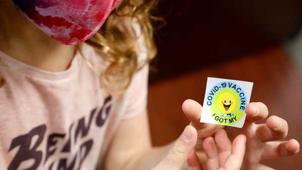 A 7 year-old child holds a sticker she received after getting the Pfizer-BioNTech Covid-19 vaccine at the Child Health Associates office in Novi, Michigan on November 3, 2021. - An expert panel unanimously recommended Pfizer-BioNTech's Covid vaccine for five- to 11-year-olds on November 2, the penultimate step in the process that will allow injections in young children to begin this week in the United States. The Centers for Disease Control and Prevention (CDC), the top US public health agency, was expected to endorse that recommendation later in the day. (Photo by JEFF KOWALSKY / AFP) (Photo by JEFF KOWALSKY/AFP via Getty Images)