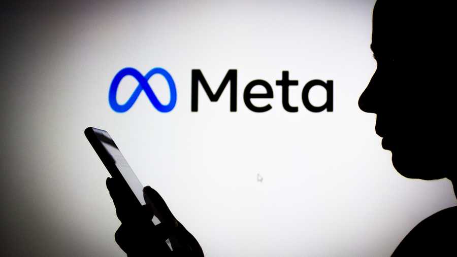 In this photo illustration the Meta Platforms logo seen in the background of a silhouette woman holding a mobile phone. (Photo Illustration by Rafael Henrique/SOPA Images/LightRocket via Getty Images)