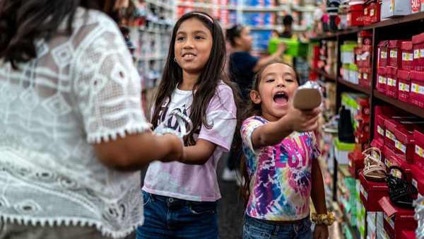 SAN ANTONIO, TX-AUG 27: Jalissa Ybarra, 9, and Kalia Ybarra, 8, go shoe shopping at South Park Mall on Saturday, Aug. 27, in San Antonio, TX. Marcela Cabralez took three of her grandchildren who live with her back to school shopping. Jalissa Ybarra, 9, was in the cafeteria of Robb Elementary when a shooter came into the school and opened fire, killing 19 students and 2 teachers. Jalissa has struggled with nightmares in the months since the shooting and expressed nervousness about going back to school. (Sergio Flores for The Washington Post via Getty Images)