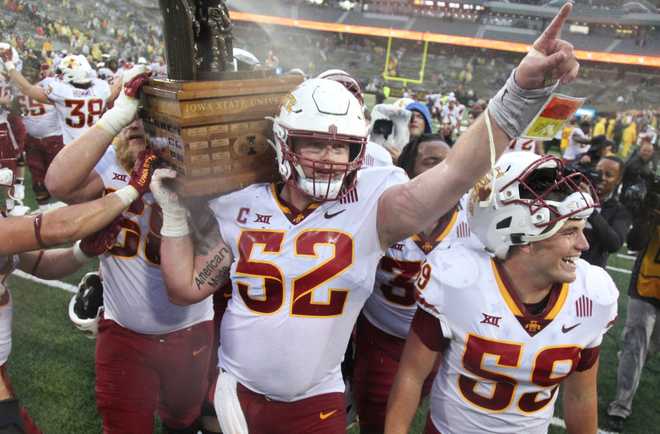 IOWA&#x20;CITY,&#x20;IOWA-&#x20;SEPTEMBER&#x20;10&#x3A;&#x20;&#x20;Offensive&#x20;lineman&#x20;Trevor&#x20;Downing&#x20;&#x23;52&#x20;of&#x20;the&#x20;Iowa&#x20;State&#x20;Cyclones&#x20;celebrates&#x20;as&#x20;he&#x20;carries&#x20;the&#x20;Cy-Hawk&#x20;trophy&#x20;off&#x20;the&#x20;field&#x20;following&#x20;the&#x20;match-up&#x20;against&#x20;the&#x20;Iowa&#x20;Hawkeyes&#x20;at&#x20;Kinnick&#x20;Stadium,&#x20;on&#x20;September&#x20;10,&#x20;2022&#x20;in&#x20;Iowa&#x20;City,&#x20;Iowa.&#x20;&#x20;&#x28;Photo&#x20;by&#x20;Matthew&#x20;Holst&#x2F;Getty&#x20;Images&#x29;
