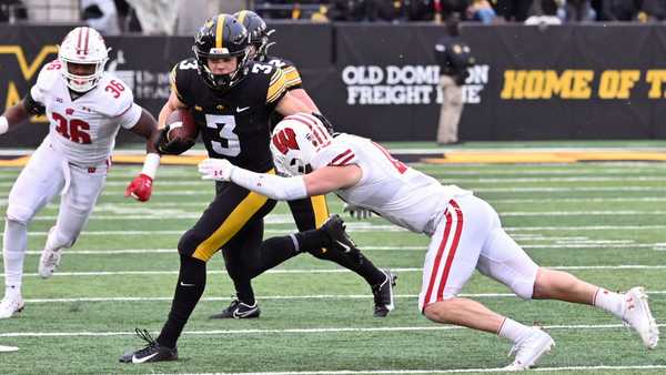 IOWA CITY, IA - NOVEMBER 12: Wisconsin strong safety John Torchio (15) tackles Iowa left cornerback Cooper DeJean (3) as he returns a punt during a college football game between the Wisconsin Badgers and the Iowa Hawkeyes, November 12, 2022, at Kinnick Stadium, Iowa City, IA. Photo by Keith Gillett/Icon Sportswire via Getty Images.
