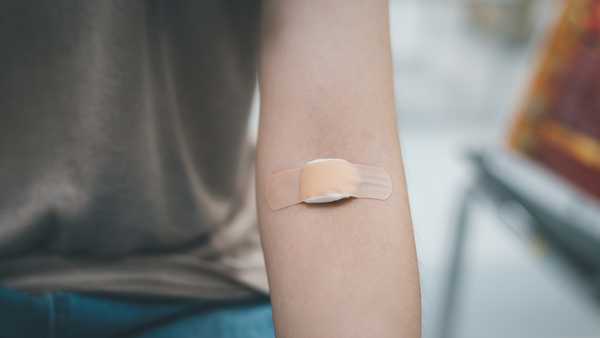Plaster and cotton on woman arm after blood testing or blood donation.