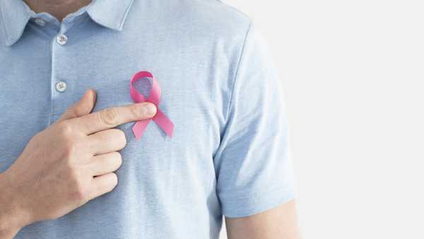 Man wearing a breast cancer awareness ribbon.