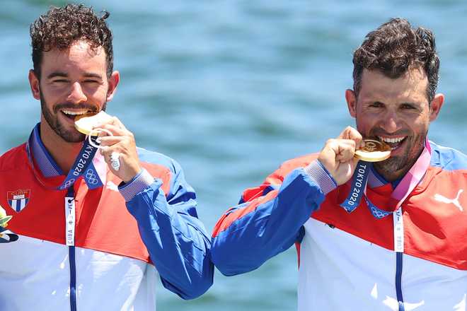 TOKYO, JAPAN - AUGUST 03: Gold medalists Serguey Torres Madrigal and Fernando Dayan Jorge Enriquez of Team Cuba celebrate during the medal ceremony for the Men&amp;apos;s Canoe Double 1000m Final A on day eleven of the Tokyo 2020 Olympic Games at Sea Forest Waterway on August 03, 2021 in Tokyo, Japan. (Photo by Elsa/Getty Images)