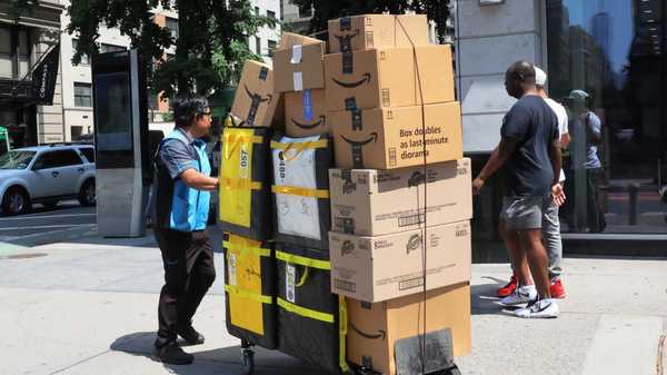 NEW YORK, NEW YORK - JULY 12: An Amazon workers pull a cart of packages for delivery on E 14th Street on July 12, 2022 in New York City. Amazon is holding Amazon Prime Day in more than 20 countries, offering exclusive discounts on thousands of products, from July 12-13. The two-day sale began on 2015 as a celebration of the retailer's 20th anniversary. (Photo by Michael M. Santiago/Getty Images)